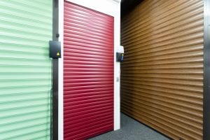green and red roller shutters and brown panelled garage door