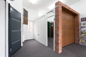 showroom with brown and white garage doors and grey security door