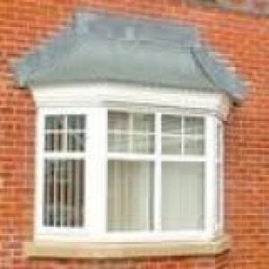 Canopies above a bay window of a red brick house
