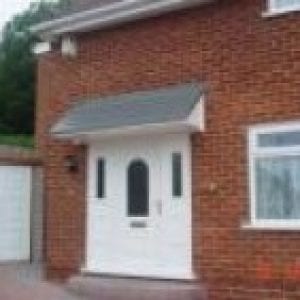 White door with a canopies above it finished dark grey slate.